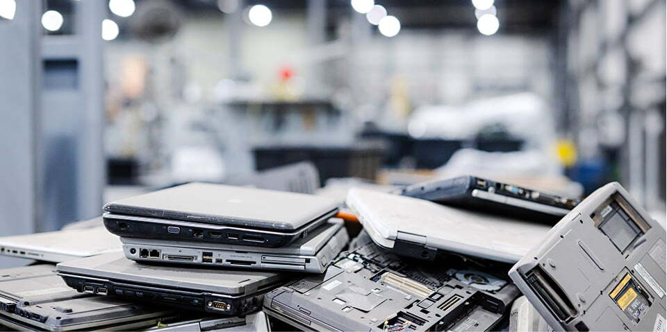 Stack of retired enterprise laptops ready for disposition