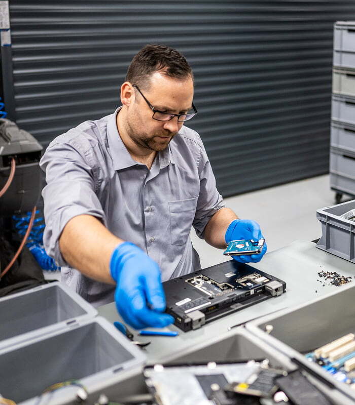 Technician removing a hard drive for secure disposition